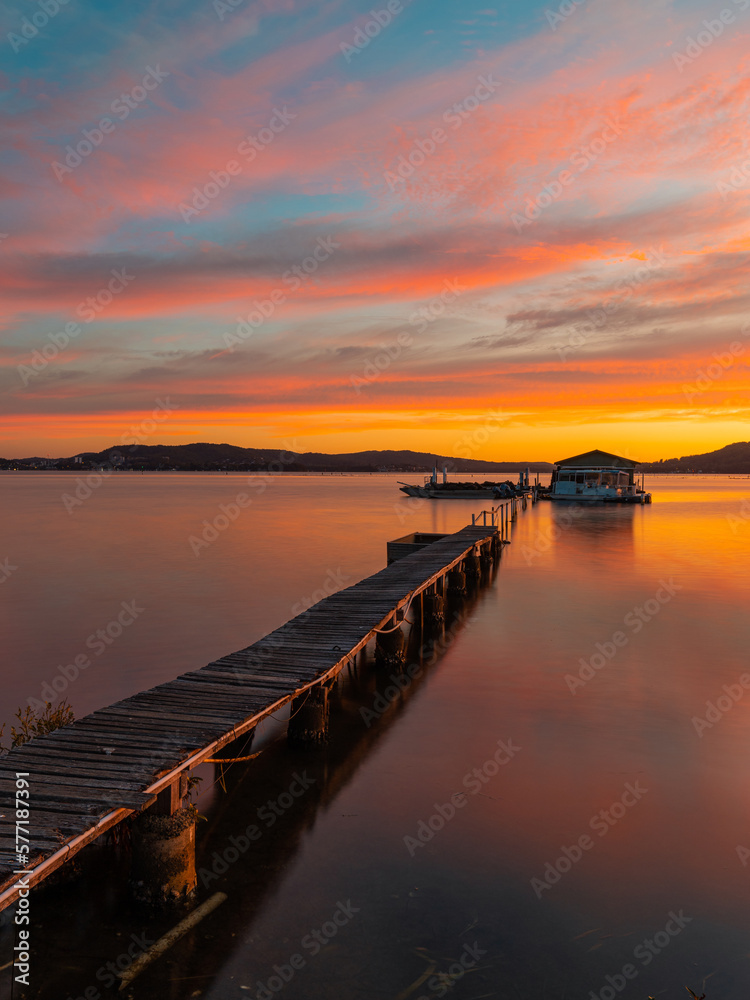 Beautiful sunrise sky over a pier at the lake.