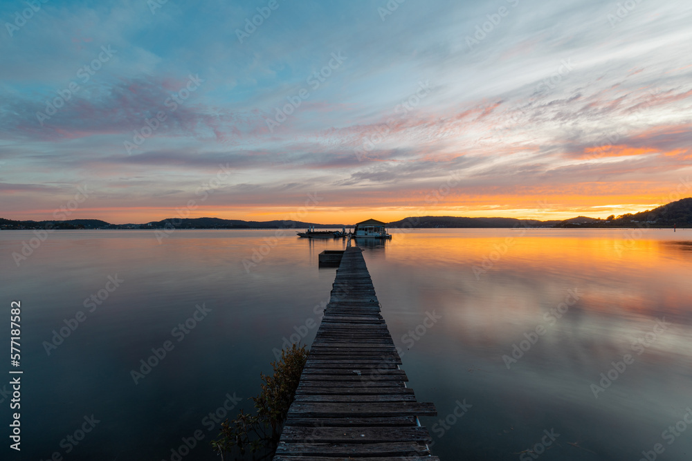 Beautiful jetty in the lake with reflection during sunrise.