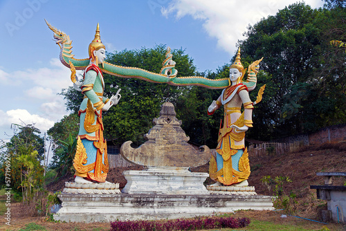 Two  Apsara holding two intertwined Naga guarding  Wat Phra That Suthon Monkhol Khiri, in Phrase province, Thailand