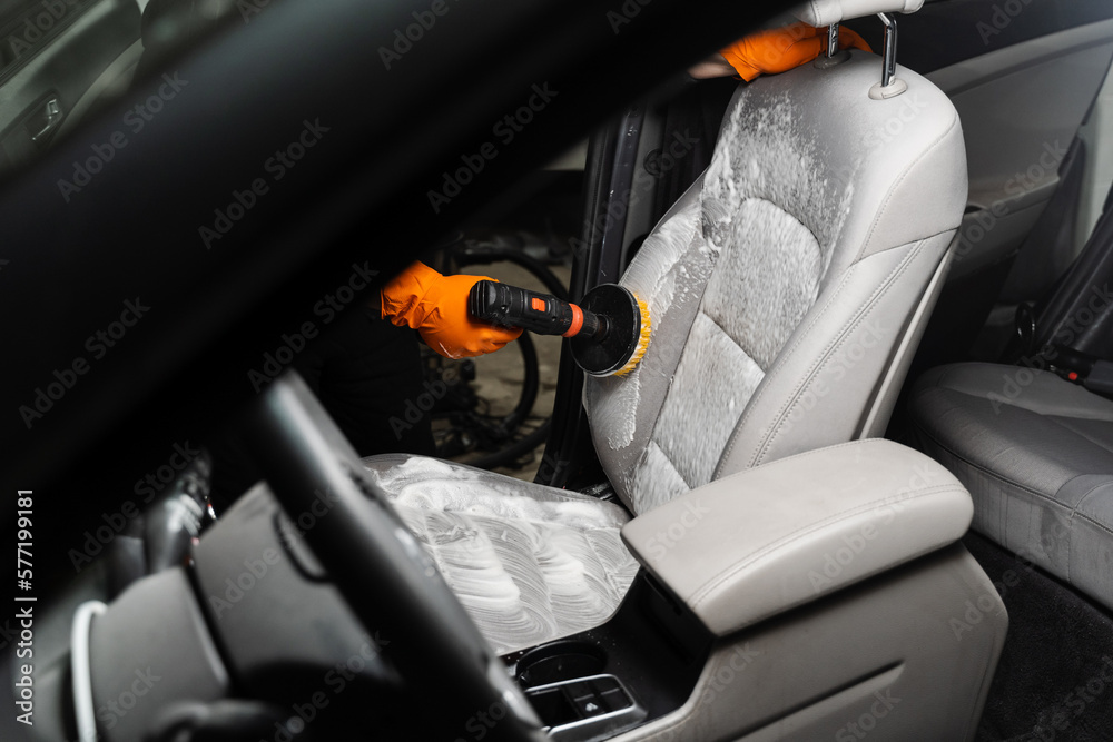 Smearing detergent on car textile seats using drill with brush for dry