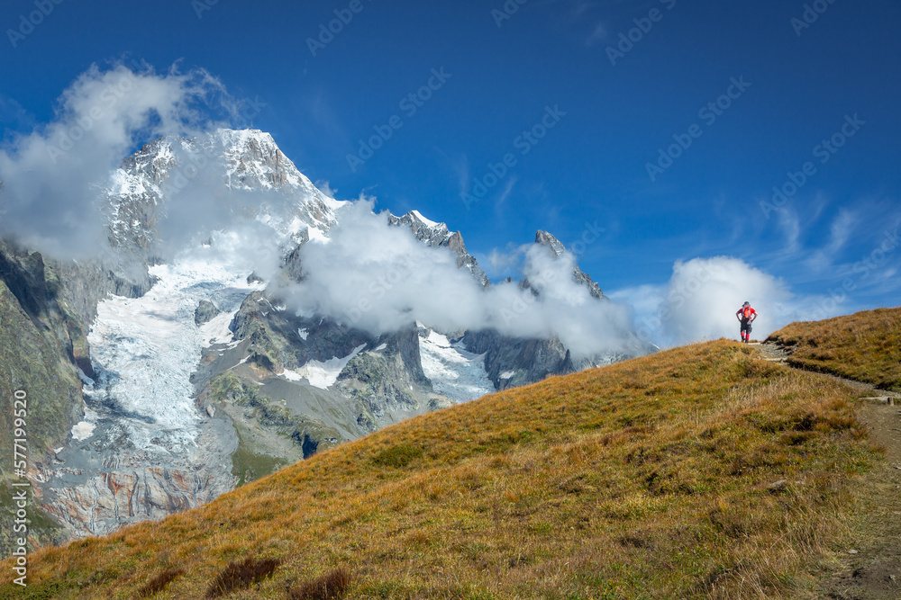 Hiker enjoying the view while hiking the Tour Du Mont Blanc from italian side
