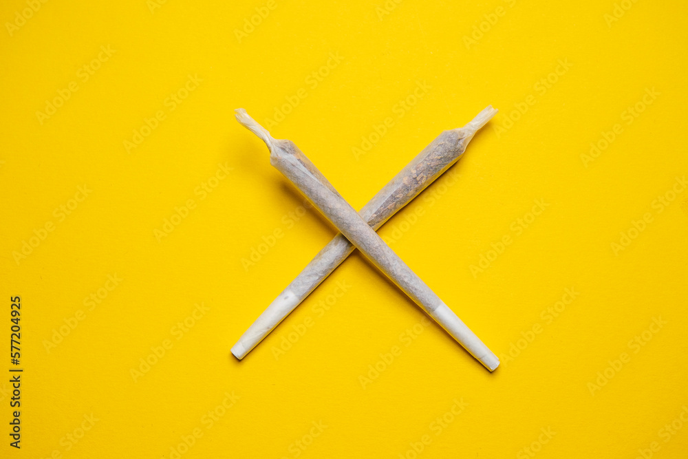 Medical Cannabis Hashish Marijuana rolled Joints isolated on a yellow background.  Cool flat lay, copy space