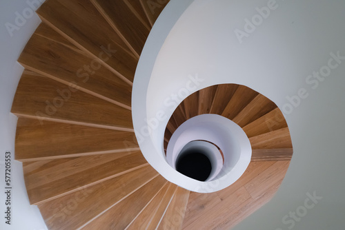 top view of wooden and white stone spiral staircase in the modern building design, indoors architecture perspective, golden ratio concept