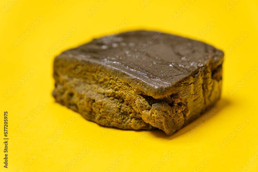 Super dry hash, medical marijuana extraction high quality fresh hashish cannabis pollen with oil on a yellow background. Super dry hash, medical marijuana extraction high quality fresh hashish cannabis pollen with oil on a yellow background.