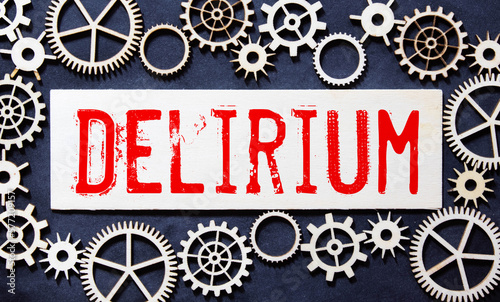 word delirium made of wooden letters on a gray table on a green background
