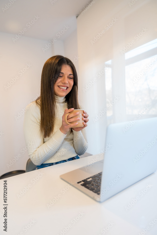 Businesswoman working on a computer with a hot coffee, business, home office, telecommuting Businesswoman working on a computer with a hot coffee, business, home office, telecommuting
