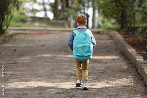 Obraz na płótnie Little boy with backpack going to school, back view