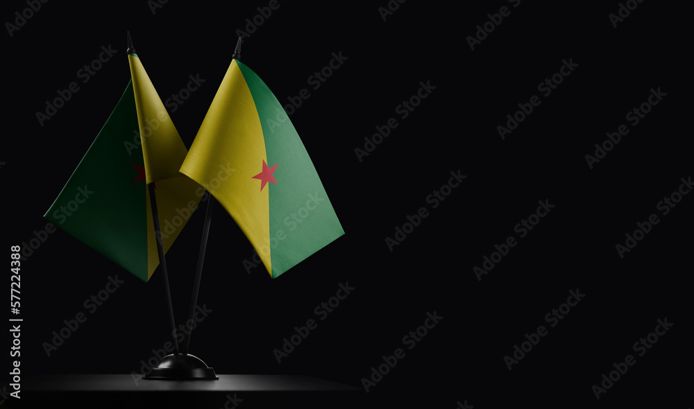 Small national flags of the French Guiana on a black background