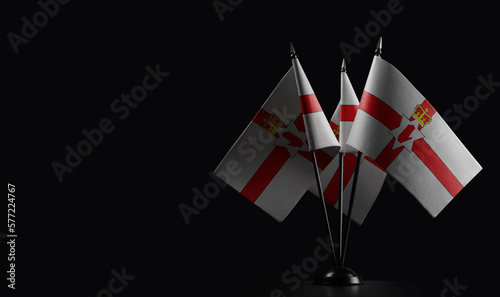 Small national flags of the Northern Ireland on a black background