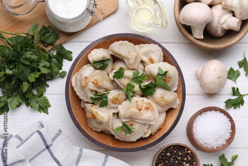 Delicious dumplings (varenyky) with potatoes, onion and parsley served on white wooden table, flat lay Delicious dumplings (varenyky) with potatoes, onion and parsley served on white wooden table, flat lay