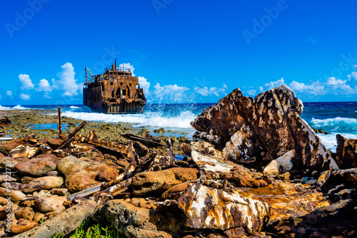 Abandoned rusty shipwreck on beach with crashing waves