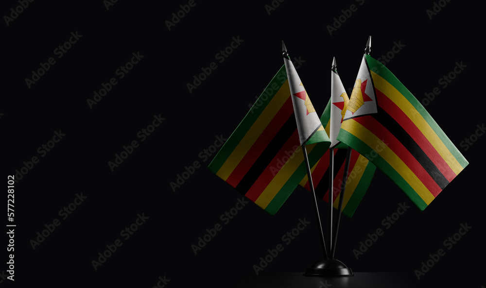 Small national flags of the Zimbabwe on a black background
