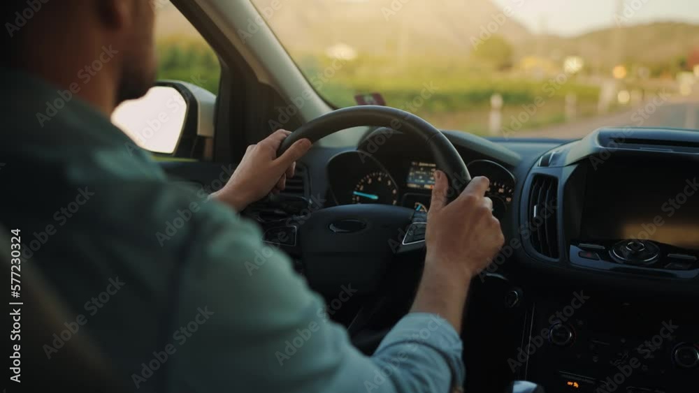 Man drives a car along the road, the setting sun shines in the windshield. Man drives a car along the road, the setting sun shines in the windshield.