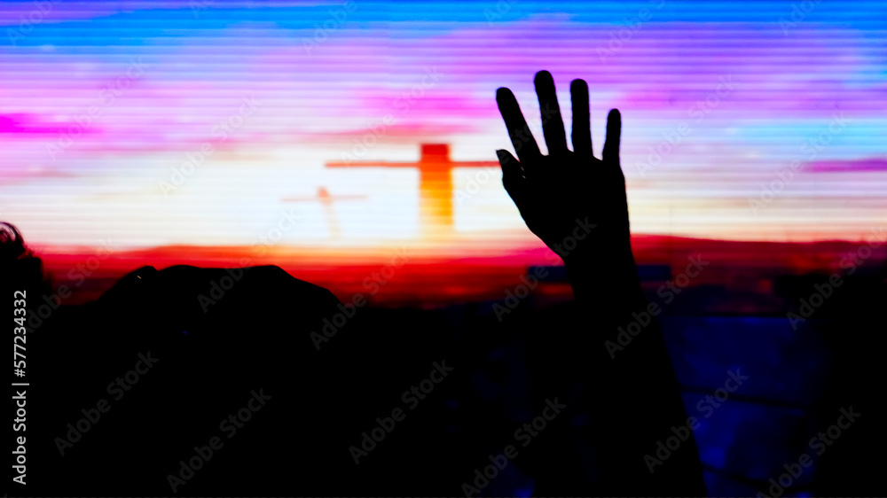 Hand raising, blurred christian cross background. 2