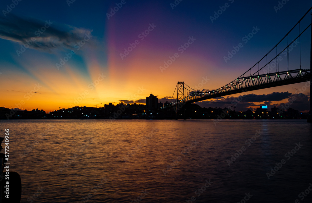 paisagem com raios coloridos no céu ocasionados pelo pôr do sol ponte Hercílio luz de Florianopolis Santa Catarina Brasil Florianópolis