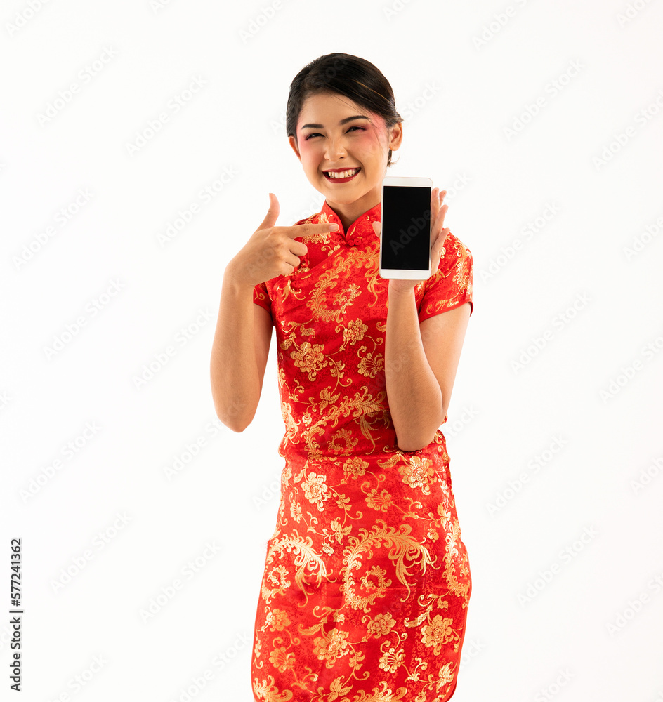 a young woman in red cheongsam standing and showing the phone at her left hand and smiling a young woman in red cheongsam standing and showing the phone at her left hand and smiling