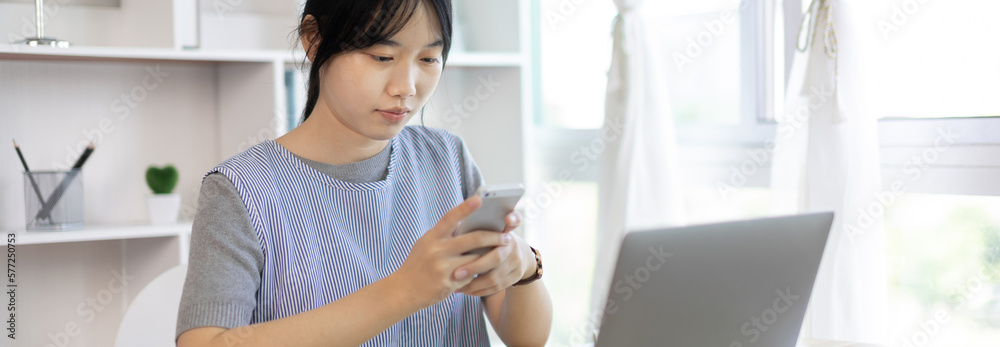 Asian woman having fun playing games on mobile phone, Play games on the sofa in the living room on weekends, Resting at home, Comfort zone, Touch screen mobile phone. Asian woman having fun playing games on mobile phone, Play games on the sofa in the living room on weekends, Resting at home, Comfort zone, Touch screen mobile phone.