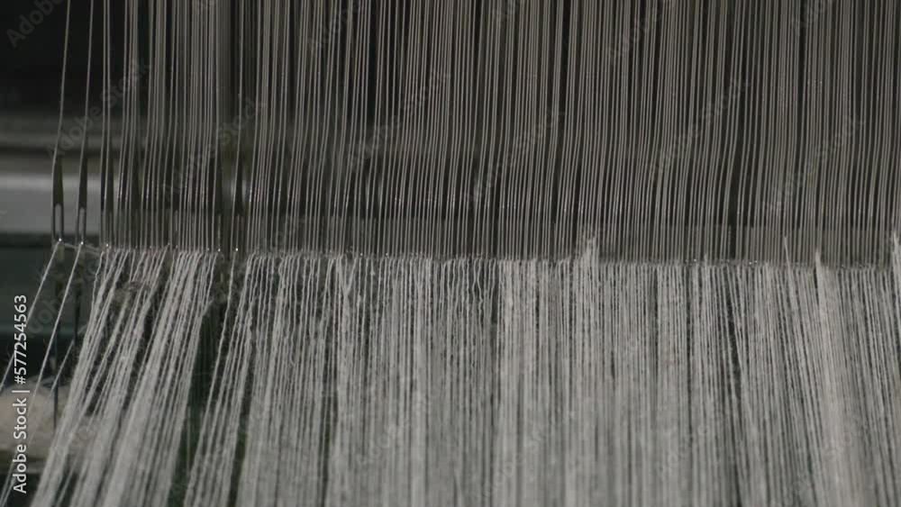 weaving loom, fabric weaving, weaving area thread needles long line. A close up of weaving machine. A loom machine for clothing or woven label. Weaving machine for garment industry. weaving loom, fabric weaving, weaving area thread needles long line. A close up of weaving machine. A loom machine for clothing or woven label. Weaving machine for garment industry.