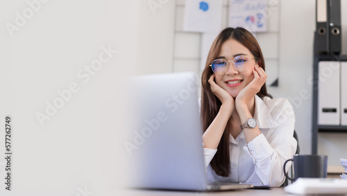 Banner with blank copyspace, Business concept, Businesswoman is touching chin on hands and reading business data on laptop