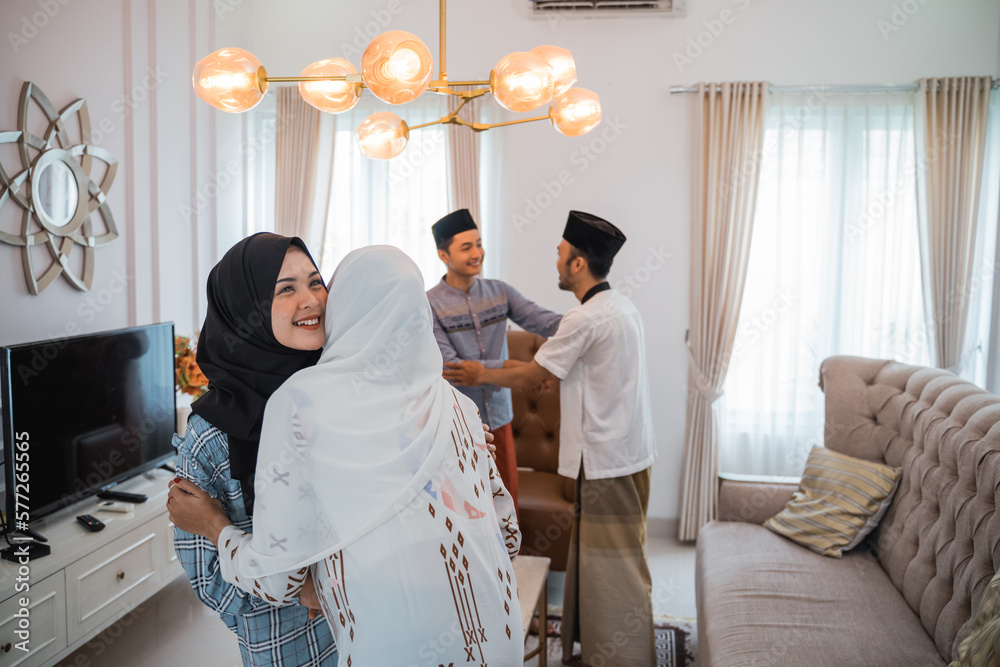 Fototapeta premium muslim friends embracing during visiting family eid celebration at home