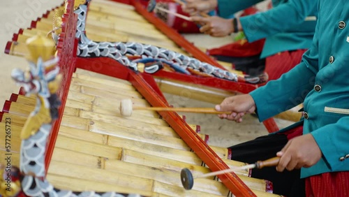 Asian musicians playing traditional bali music on ceremony in temple. Close up of man's in national balinese clothing, dress use bamboo instrument xylophone Rindik for hindu rhythm photo