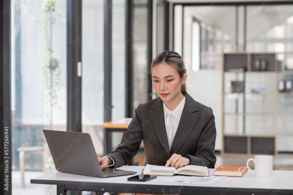 Young Asian businesswoman using tablet to work in office Young Asian businesswoman using tablet to work in office