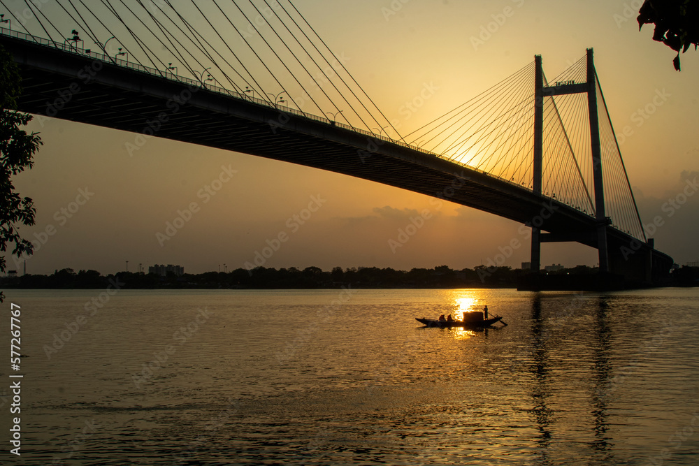 Boat in the river Ganges at Kolkata It is a toll bridge over the Hooghly River in West Bengal, India, linking the cities of Kolkata and Howrah.