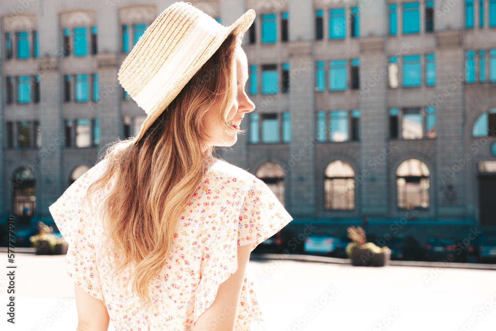 Beautiful smiling brunette model. Trendy female posing in the street background. Funny and positive woman having fun outdoors at sunset. In hat at sunny day. In dress. Cheerful and happy