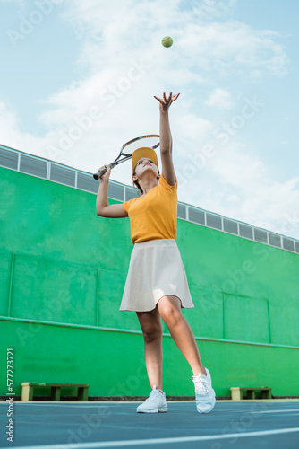 tennis player serving while throwing ball will hit with racket on tennis court © Odua Images