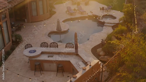 A desert landscaped backyard located in Arizona featuring
a travertine tiled pool deck outdoors kitchen and fireplace.