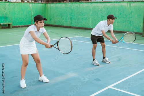 mixed doubles athlete ready to receive the ball while playing on the tennis court © Odua Images