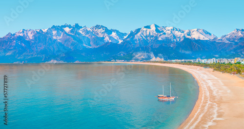 Fototapeta Naklejka Na Ścianę i Meble -  Brown gulet anchored at the Aegean sea - Panoramic view of beautiful blue Antalya bay and Konyaalti (konya alti) beach  - Antalya Turkey