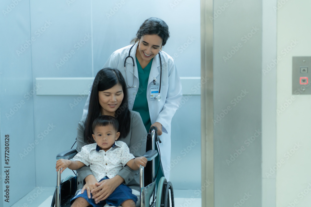 A pediatrician helps to push wheelchair mothers and children to examine the body in a special room of the hospital A pediatrician helps to push wheelchair mothers and children to examine the body in a special room of the hospital