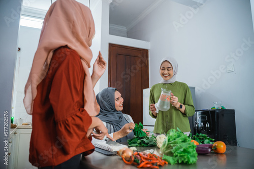 beautiful muslim woman cooking for dinner at friends home during ramadan photo