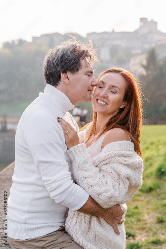 A loving couple hugging, a man gently kisses a woman