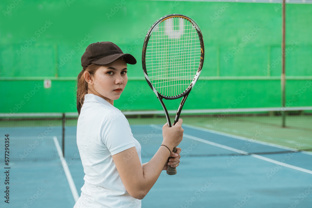 Tennis athlete looking back while holding racket on tennis court