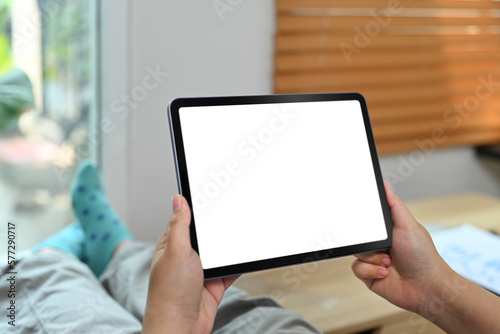 Close up view of woman using digital tablet in living room. Blank display for graphic display montage
