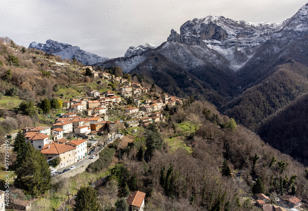 Fototapeta premium Toscana, Alpi Apuane: il paese di Stazzema con le vette del monte Procinto e del monte Nona innevate sullo sfondo