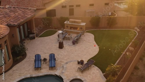 A desert landscaped backyard located in Arizona featuring
a travertine tiled pool deck outdoors kitchen and fireplace.