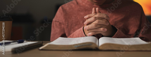 Photography Young boy is sitting and holding hand for pray, read holy bible  and worship jesus christ in the morning at the church