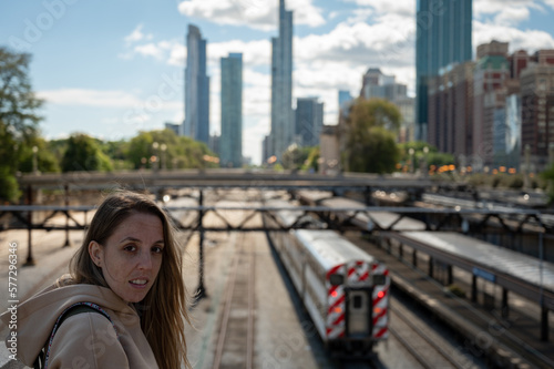 Portrait of young girl in long hair blonde with sweatshirt on Chicago train station bridge