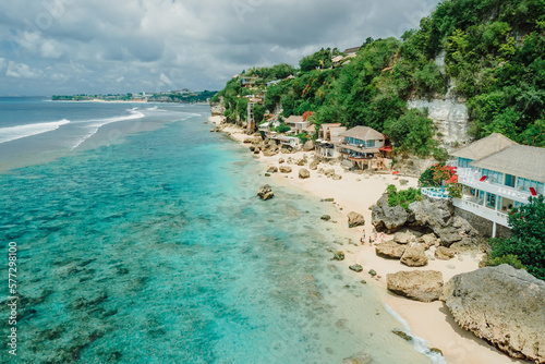 Aerial view of quiet ocean and beach coastline with cozy hotels on Impossibles beach in Bali