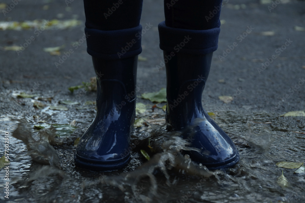 Person in rubber boots outdoor in rainy weather Person in rubber boots outdoor in rainy weather