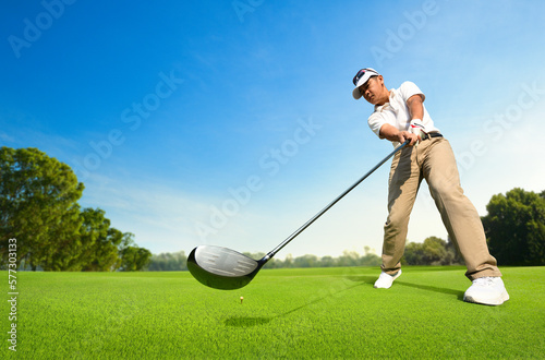 Motion action of golfer after hitting golf ball on tee.
