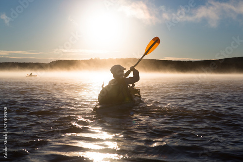 Two women paddle their kayaks on the Amur river in far East Russia. photo