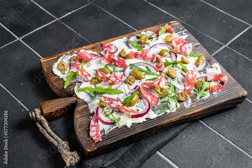 Butterboard, Butter Board with olives, onion, arugula, capers and tomato. Black background. Top view photo