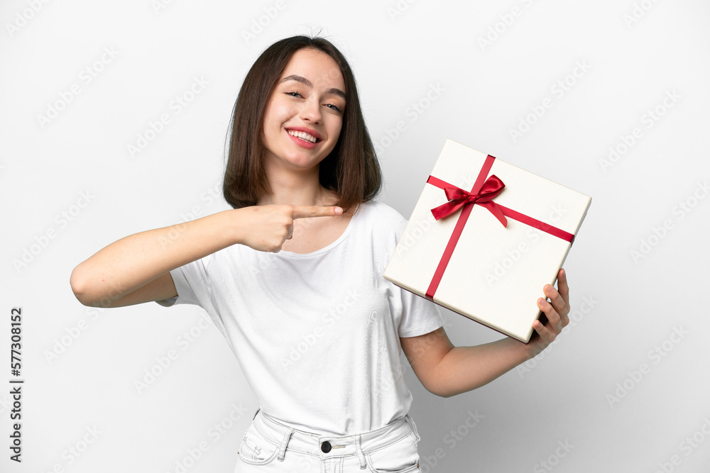 Young Ukrainian woman holding a gift isolated on white background and pointing it Young Ukrainian woman holding a gift isolated on white background and pointing it