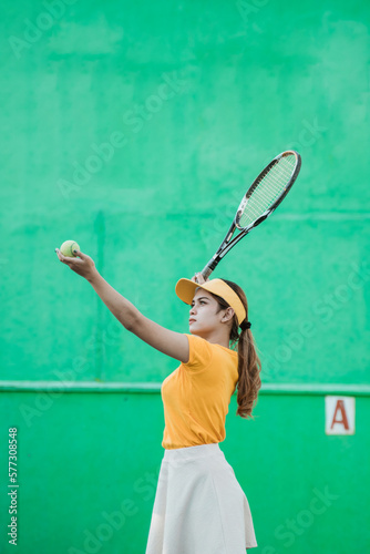 Female tennis player concentrating on serving holding ball with racket to hit on tennis court © Odua Images