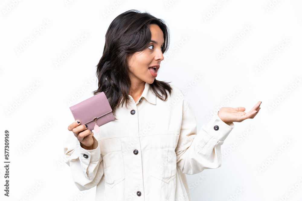 Young hispanic woman holding wallet isolated on white background with surprise expression while looking side Young hispanic woman holding wallet isolated on white background with surprise expression while looking side