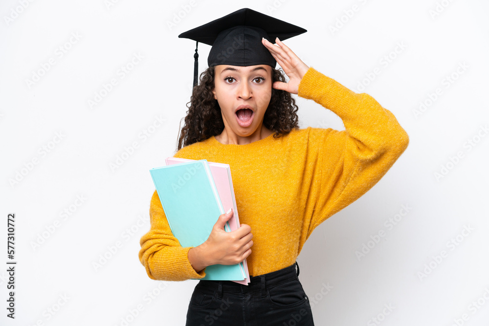 Arab university graduate woman holding books isolated on white background with surprise expression Arab university graduate woman holding books isolated on white background with surprise expression